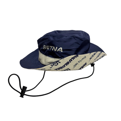 Navy blue sun hat with white brim and 'Setina' branding on a white background